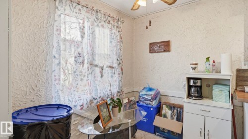 Room with textured wall finish and a window featuring sheer patterned curtains - 12 14120 80 Street, Edmonton, AB - Indoor