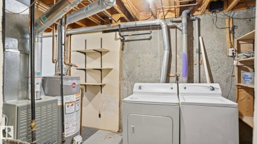 Utility area featuring a furnace, water heater, and a side-by-side washer and dryer - 12 14120 80 Street, Edmonton, AB - Indoor