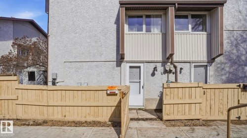 Light stucco exterior with vertical accent siding and two upper-level windows - 12 14120 80 Street, Edmonton, AB - Outdoor With Exterior