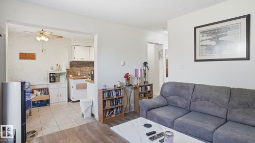 Bright living space featuring wood-finish flooring transitioning to tile in the kitchen area - 12 14120 80 Street, Edmonton, AB - Indoor Photo Showing Living Room