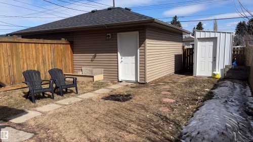 The property features a detached garage with horizontal siding and a dark shingle roof, accompanied by a separate storage shed - 10231 163 Street, Edmonton, AB - Outdoor With Exterior