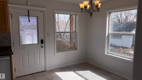 This inviting space features light-colored walls, tile flooring, and a multi-light chandelier - 10231 163 Street, Edmonton, AB - Indoor Photo Showing Other Room