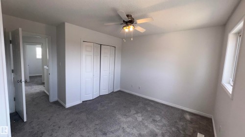 This room features neutral-toned carpet, white walls, and a ceiling fan with integrated lighting - 10231 163 Street, Edmonton, AB - Indoor Photo Showing Other Room