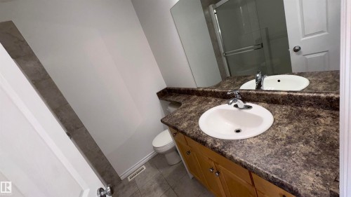 Bathroom featuring a vanity with two sinks, a large mirror, and tiled flooring - 10231 163 Street, Edmonton, AB - Indoor Photo Showing Bathroom