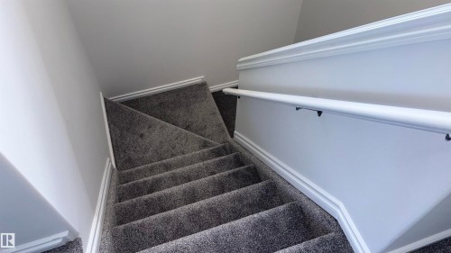 Staircase with gray carpeted treads, white baseboards, and a white handrail - 10231 163 Street, Edmonton, AB - Indoor Photo Showing Other Room