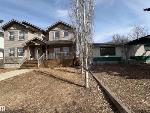 The property features a two-story structure with siding and stone accents, a covered front entrance, and a porch with white railings - 10231 163 Street, Edmonton, AB - Outdoor With Deck Patio Veranda With Facade