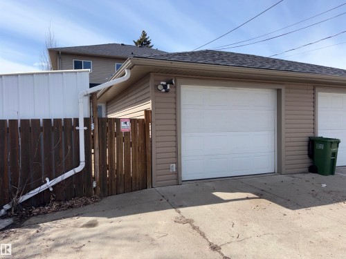 The property features a garage with a white overhead door and tan siding - 10231 163 Street, Edmonton, AB - Outdoor With Exterior