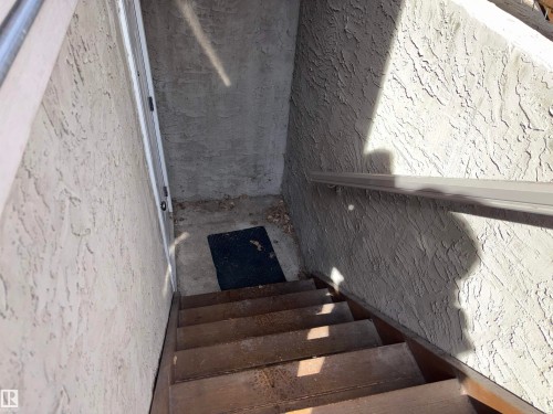 Exterior steps leading to an entrance, featuring a handrail and textured stucco walls - 10231 163 Street, Edmonton, AB - Indoor Photo Showing Other Room