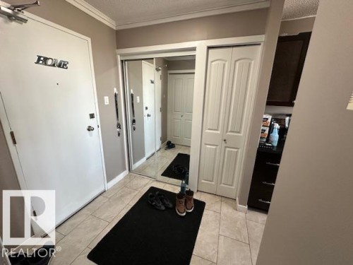 Entry foyer featuring large format tile flooring, a mirrored closet door, and a paneled closet door - 86 13435 97 Street, Edmonton, AB - Indoor Photo Showing Other Room