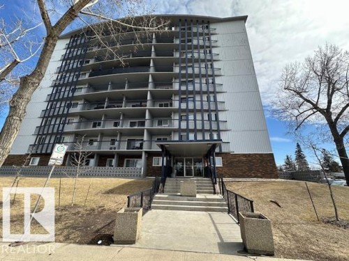 Multi-story building featuring a prominent entrance with concrete steps and black metal railings - 86 13435 97 Street, Edmonton, AB - Outdoor With Balcony With Facade