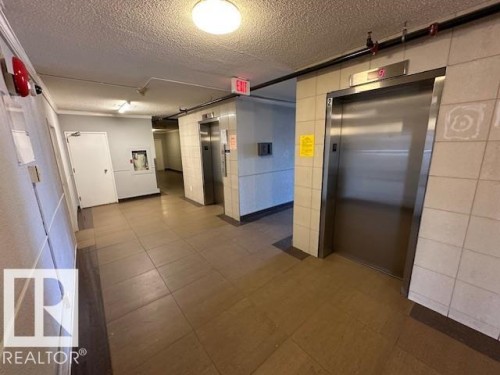 Elevator lobby with ceramic tile flooring, two stainless steel elevators, and recessed ceiling lighting - 86 13435 97 Street, Edmonton, AB - Indoor Photo Showing Garage