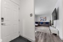 Entryway featuring a paneled door with modern hardware, leading to a living area with wood-finish flooring - 7 14115 82 Street, Edmonton, AB  - Indoor Photo Showing Other Room 