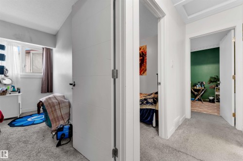 Carpeted hallway with white interior doors featuring horizontal paneling - 7 14115 82 Street, Edmonton, AB - Indoor Photo Showing Other Room