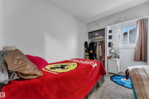 Bedroom featuring light gray walls, textured carpeting, and a window with a white frame - 7 14115 82 Street, Edmonton, AB - Indoor Photo Showing Bedroom
