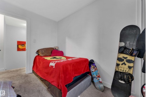 Carpeted interior room featuring neutral wall tones, baseboard trim, and a doorway with white casing - 7 14115 82 Street, Edmonton, AB - Indoor Photo Showing Bedroom