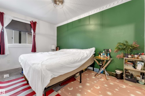 Room featuring a single window with a roller shade, a decorative ceiling fixture, and a single accent wall - 7 14115 82 Street, Edmonton, AB - Indoor Photo Showing Bedroom