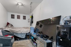 White-painted room featuring a single overhead light fixture, a ceiling vent, and a mirrored media console - 