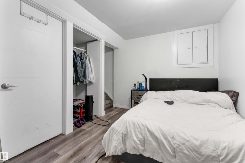 Bedroom featuring wood-finish flooring and a built-in closet with an open doorway - 7 14115 82 Street, Edmonton, AB - Indoor Photo Showing Bedroom