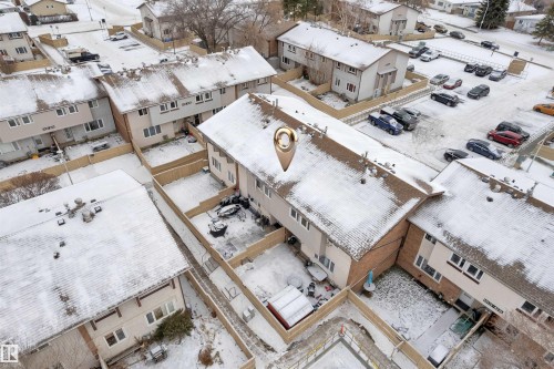Townhome with a fenced backyard, shingled roof, light-colored siding, and a paved parking area - 7 14115 82 Street, Edmonton, AB - Outdoor With View