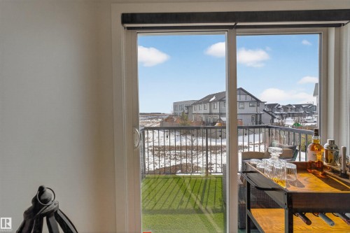 This property features a sliding glass door that opens to a balcony with a black metal railing - 28 6214 Cartmell Crest, Edmonton, AB - Indoor