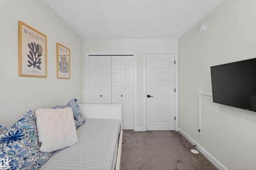 The room features light gray walls, a textured ceiling, and gray carpeted flooring - 28 6214 Cartmell Crest, Edmonton, AB - Indoor Photo Showing Bedroom