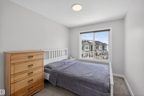 This room features light gray walls, a window providing natural light, and carpeted flooring - 28 6214 Cartmell Crest, Edmonton, AB - Indoor Photo Showing Bedroom