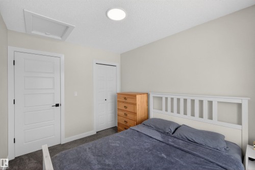 This space features light-colored walls and a textured ceiling with a recessed light fixture - 28 6214 Cartmell Crest, Edmonton, AB - Indoor Photo Showing Bedroom