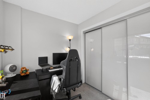 This room features a neutral wall color, carpeted flooring, and sliding closet doors - 28 6214 Cartmell Crest, Edmonton, AB - Indoor