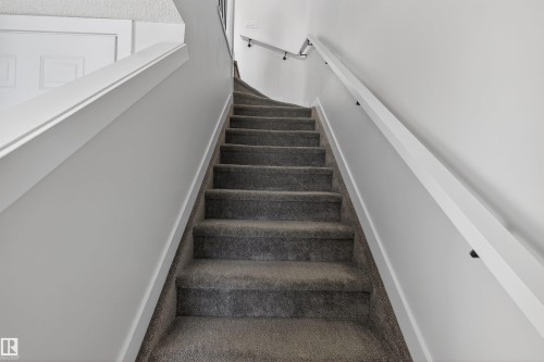 Well-maintained staircase featuring carpeted treads and risers, white walls, and a handrail - 28 6214 Cartmell Crest, Edmonton, AB - Indoor Photo Showing Other Room