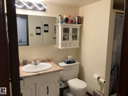 Bathroom featuring a vanity with a cultured marble countertop, an integrated sink, and white cabinetry - 