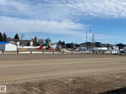 Community playground featuring colorful play structures, open recreational space, and surrounding residential properties - 