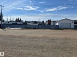 White siding exterior with a prominent attached garage featuring a white overhead door - 
