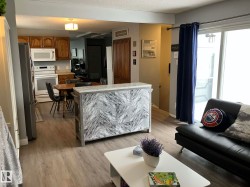 Open-concept living area with wood-finish flooring - 