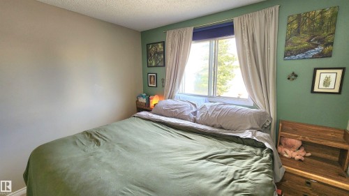 Bedroom featuring a window with natural light, two-tone painted walls, and a textured ceiling - 3531 46 Street, Edmonton, AB - Indoor Photo Showing Bedroom