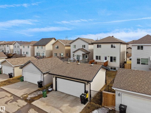 Rear elevation featuring a wooden deck with railing, a walk-out basement, and a fully fenced yard - 5192 1B Avenue Sw, Edmonton, AB - Outdoor