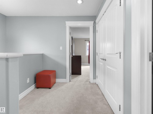 Carpeted hallway featuring light gray walls, white trim, recessed lighting, and white paneled doors - 5192 1B Avenue Sw, Edmonton, AB - Indoor Photo Showing Other Room