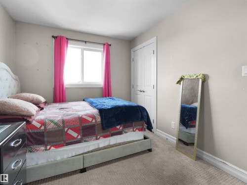 Bedroom featuring light neutral wall paint, carpet flooring, a white window frame, and a white interior door - 5192 1B Avenue Sw, Edmonton, AB - Indoor Photo Showing Bedroom