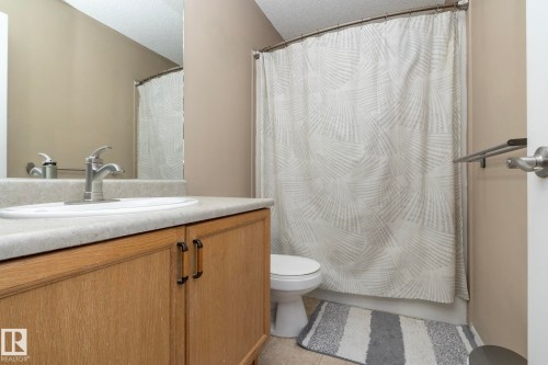 Bathroom featuring a light wood-finish vanity with a built-in white sink and chrome faucet - 50 14803 Miller Boulevard, Edmonton, AB - Indoor Photo Showing Bathroom