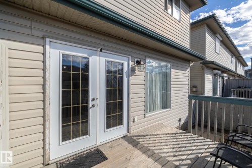 Private deck featuring white railing and wood-finish flooring - 50 14803 Miller Boulevard, Edmonton, AB - Outdoor With Deck Patio Veranda With Exterior