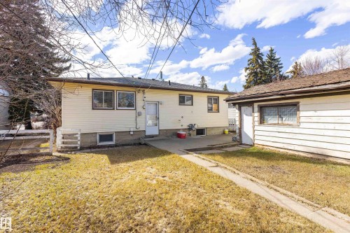 Rear exterior of the property featuring cream-colored siding and a concrete patio - 9007 149 Street, Edmonton, AB - Outdoor