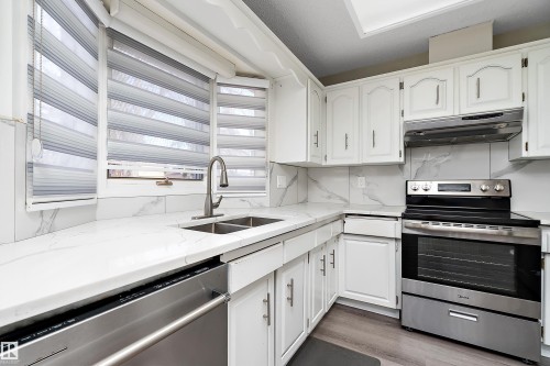 Kitchen featuring white cabinetry, a stainless steel range, and a double basin sink with a gooseneck faucet - 11020 158 Avenue, Edmonton, AB - Indoor Photo Showing Kitchen With Double Sink