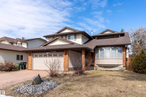 The property features a brick and stucco exterior, a two-car garage, and a paved driveway - 11020 158 Avenue, Edmonton, AB - Outdoor