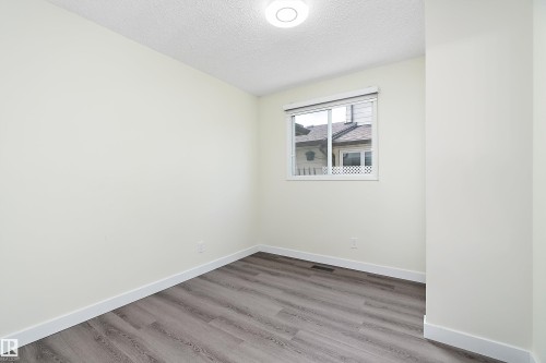 This room offers light-colored walls, durable flooring, and a ceiling-mounted light fixture - 11020 158 Avenue, Edmonton, AB - Indoor Photo Showing Other Room