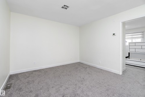 This room features light gray carpeting and white walls, offering a neutral palette - 11020 158 Avenue, Edmonton, AB - Indoor Photo Showing Other Room