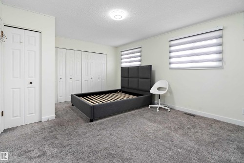 This room features soft grey carpeting, light-colored walls, and a ceiling light fixture - 11020 158 Avenue, Edmonton, AB - Indoor Photo Showing Bedroom