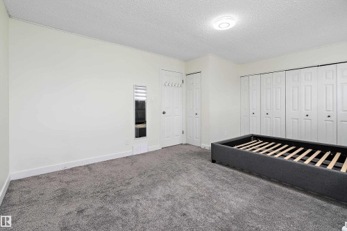 This room features light-colored walls and dark gray carpet flooring - 11020 158 Avenue, Edmonton, AB - Indoor Photo Showing Other Room