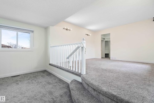 The property features a spacious room with light-colored walls and grey carpeting - 11020 158 Avenue, Edmonton, AB - Indoor Photo Showing Other Room