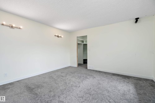 Spacious room featuring light grey carpet, white walls, and built-in lighting fixtures - 11020 158 Avenue, Edmonton, AB - Indoor Photo Showing Other Room