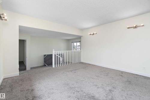 The property features a spacious room with light gray carpeting and white walls - 11020 158 Avenue, Edmonton, AB - Indoor Photo Showing Other Room