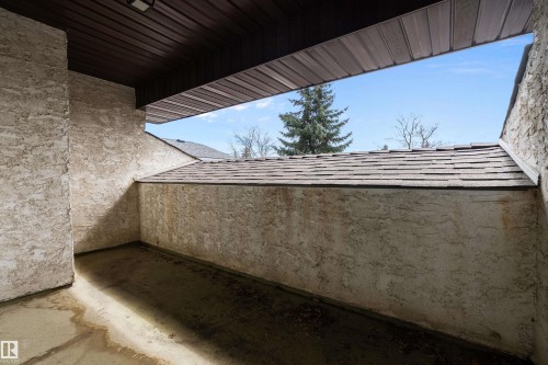 The property features an exterior with textured walls, a dark brown slatted overhang, and a view of a pitched roof with shingles - 11020 158 Avenue, Edmonton, AB - Outdoor